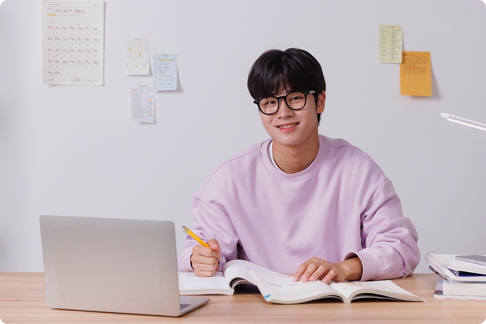 책과 노트북을 확인하는 학생