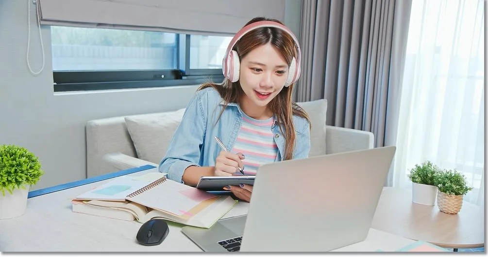 헤드폰과 노트북으로 자료를 보는 학생