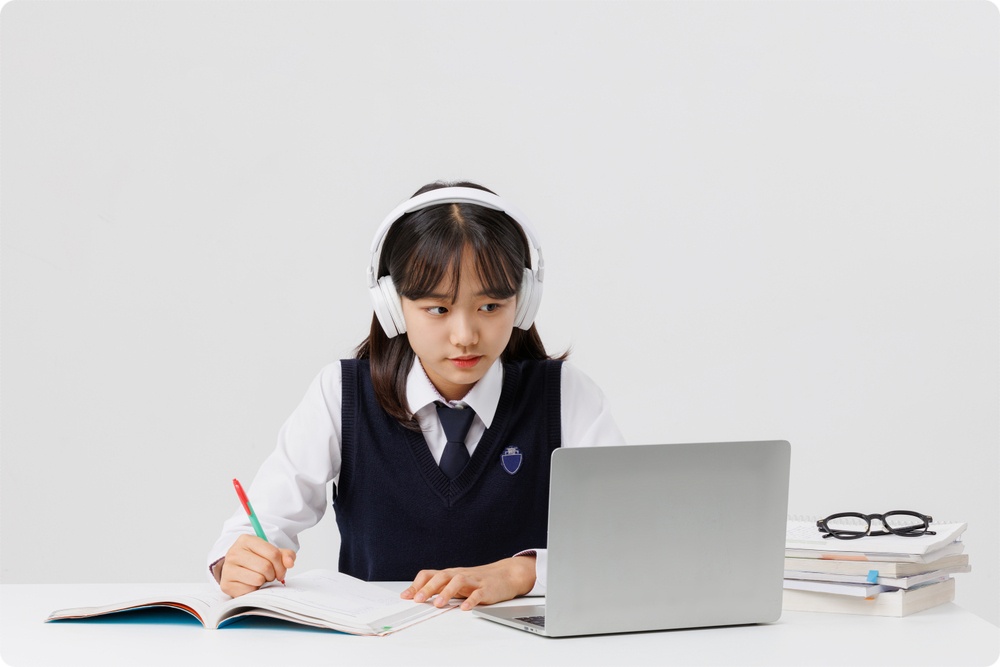 헤드폰과 노트북으로 학습하는 학생