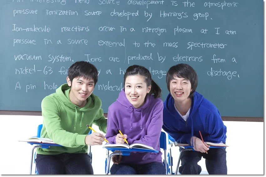 칠판 앞에서 책을 보는 학생들