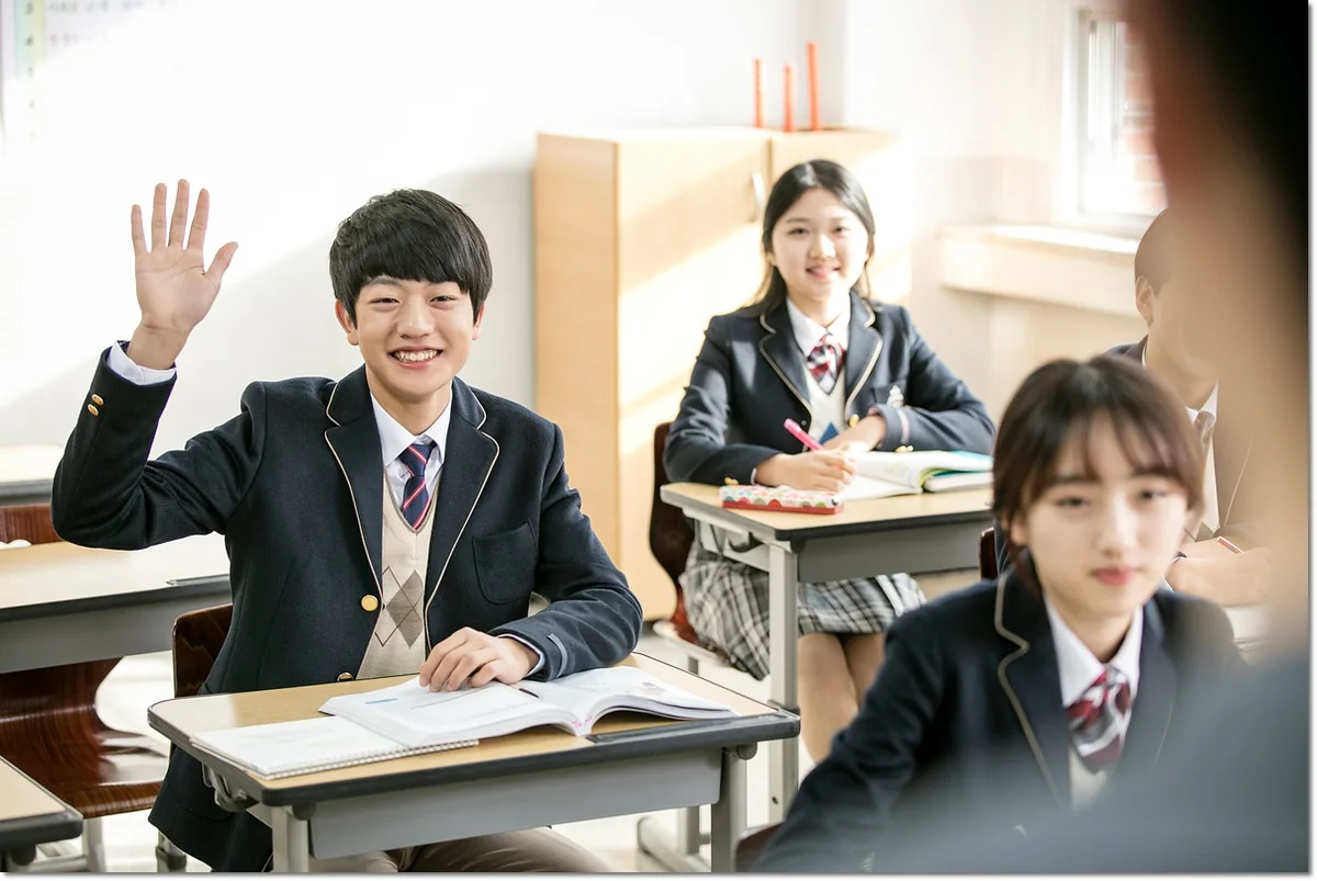 교실에서 손을 들어 질문하는 학생