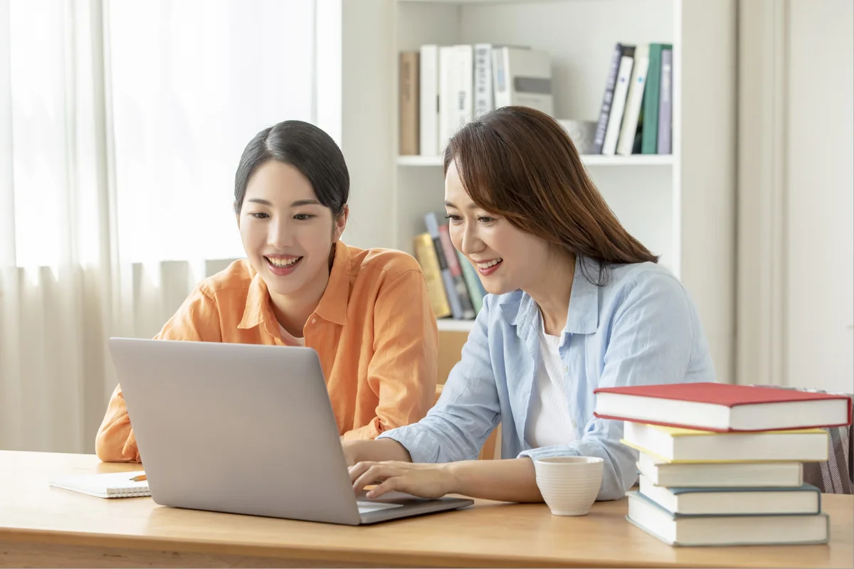 노트북 화면을 함께 확인하는 어른과 학생