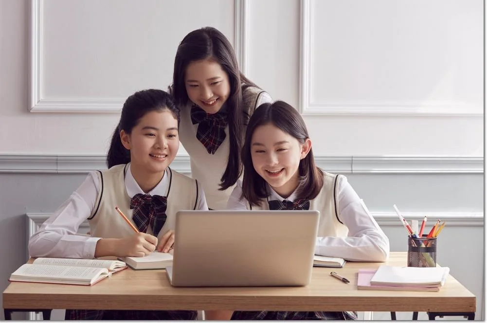 교실에서 노트북 자료를 함께 보는 교사와 학생들