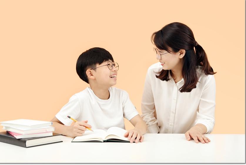 학습 자료를 두고 이야기하는 어른과 학생