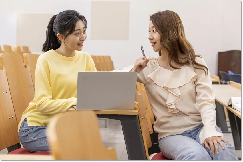 노트북을 앞에 두고 대화하는 어른과 학생