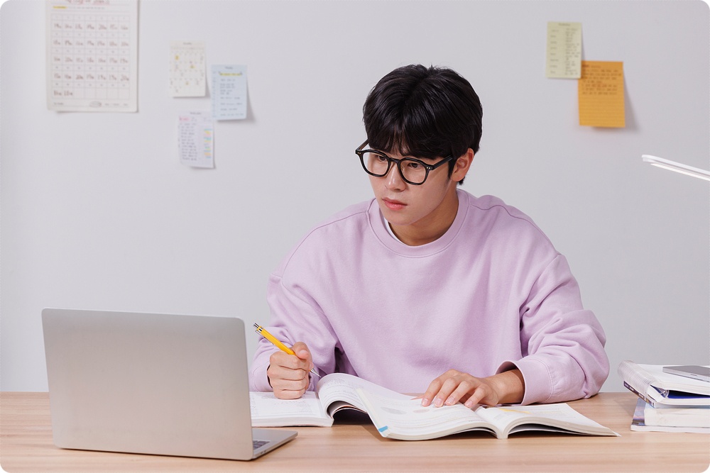 노트북과 책을 보는 학생