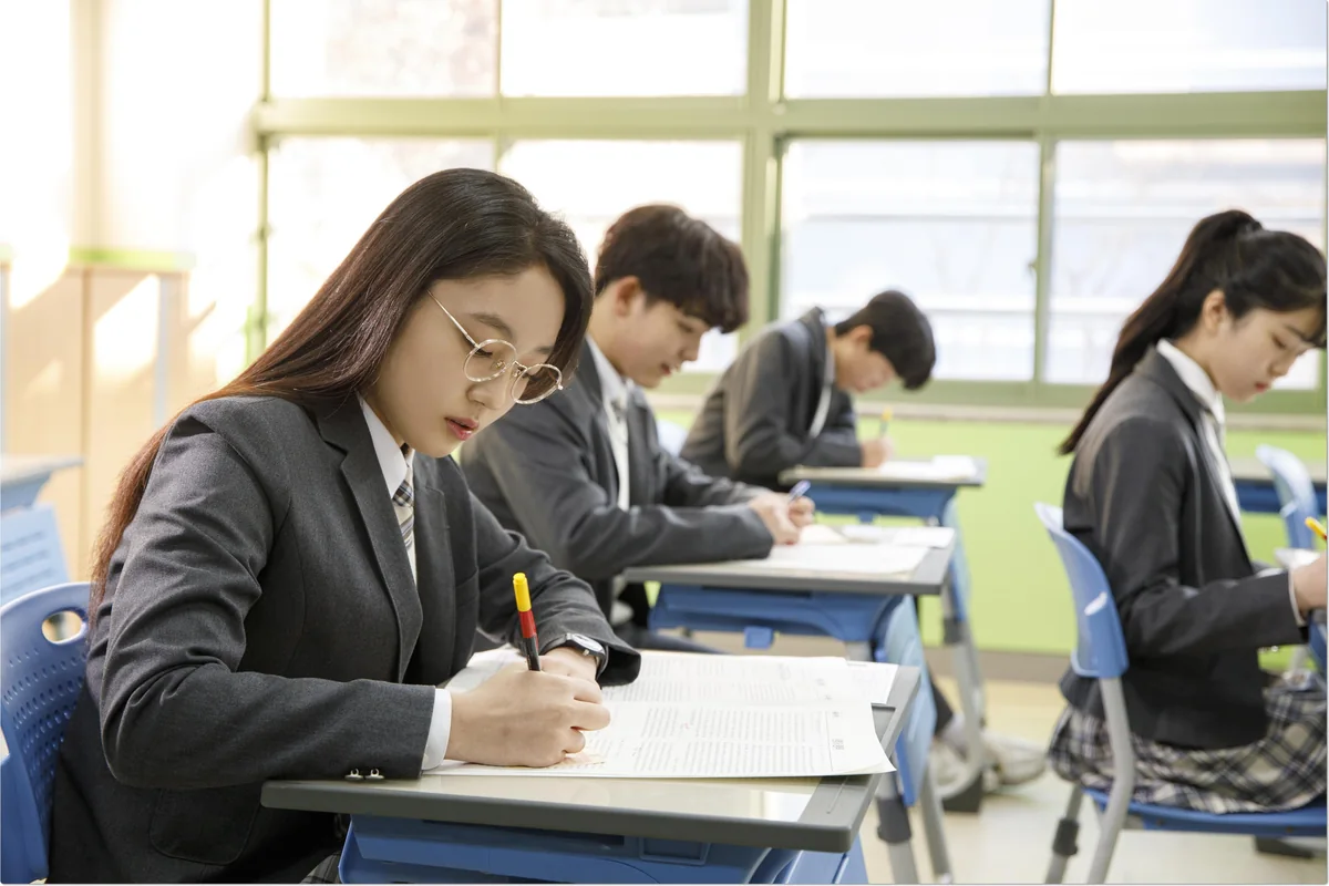 교실에서 함께 필기하는 학생들